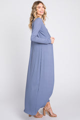 woman wearing a long, light blue ribbed maxi dress with long sleeves and a relaxed fit