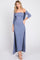 woman wearing a light blue ribbed off-the-shoulder maxi dress with a long cardigan and strappy sandals