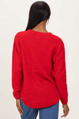 woman wearing a bright red textured sweater with a relaxed fit and long sleeves, viewed from the back