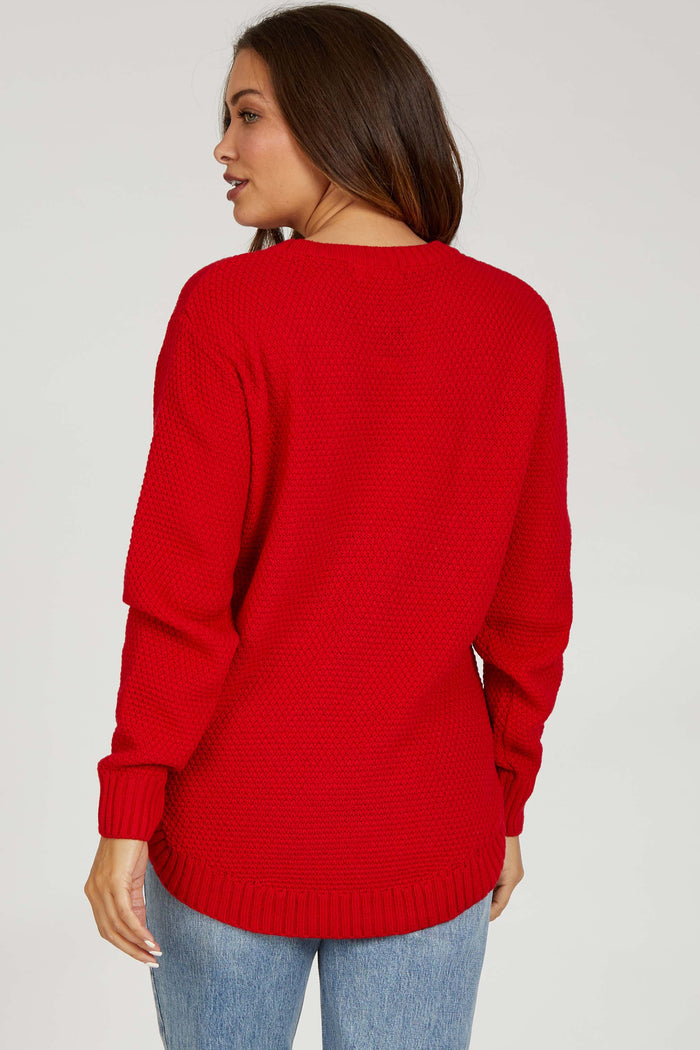 woman wearing a red knitted maternity sweater with a relaxed fit, showing the back view