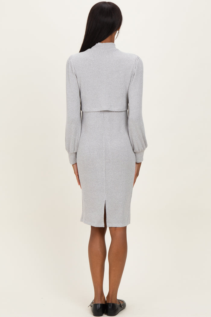 woman wearing a light gray ribbed midi dress with long puff sleeves and a fitted silhouette, viewed from the back