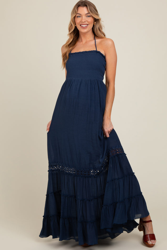 woman wearing a navy blue strapless maternity maxi dress with tiered ruffles and lace detail