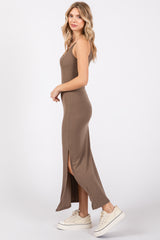 woman wearing a fitted brown ribbed maxi dress with side slits and white sneakers