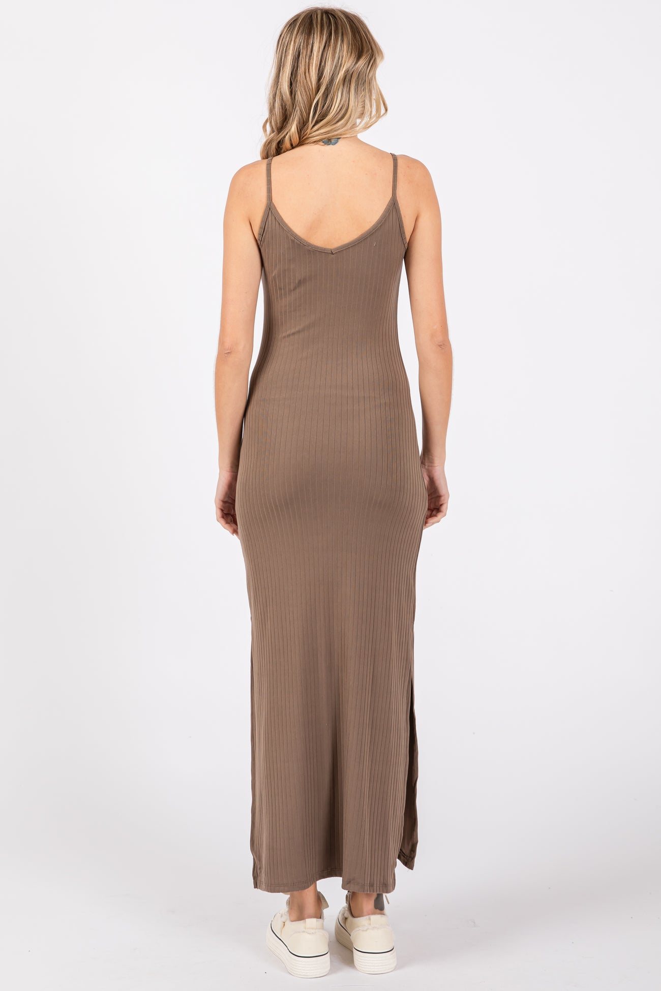 woman wearing a brown ribbed maxi dress with spaghetti straps and side slits, shown from the back