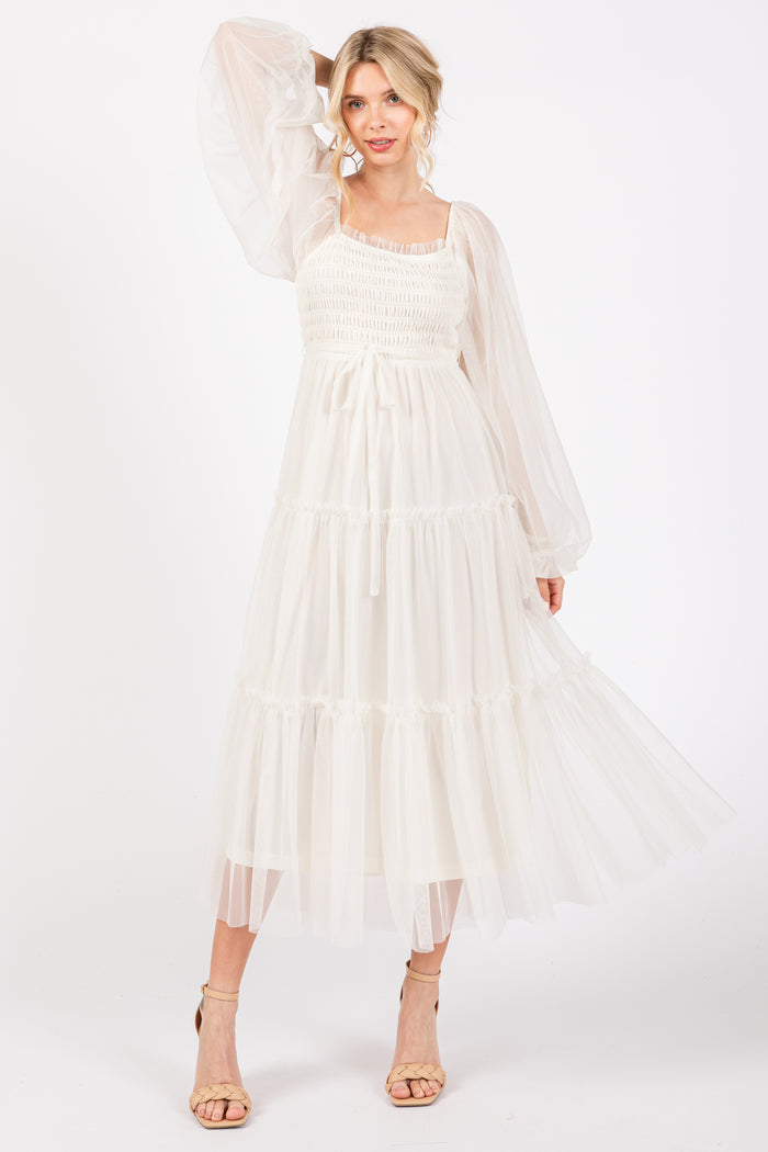 woman wearing a white tiered maxi dress with puff sleeves and smocked bodice