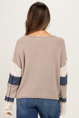 woman wearing a beige and white striped maternity sweater with navy details, showing the back view