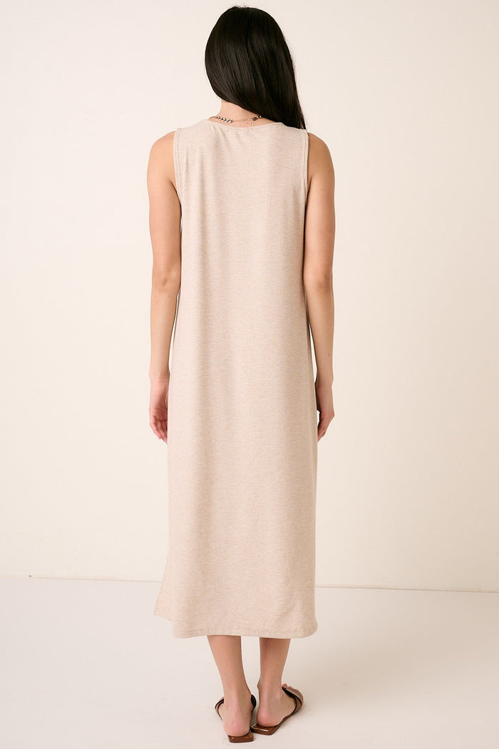 woman wearing a long beige sleeveless maxi dress, viewed from the back, with a relaxed fit and simple design