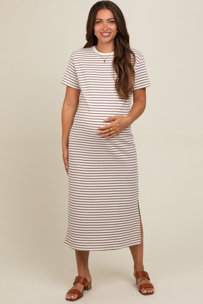 woman wearing a brown and white striped maternity dress with short sleeves and a side slit, holding her baby bump