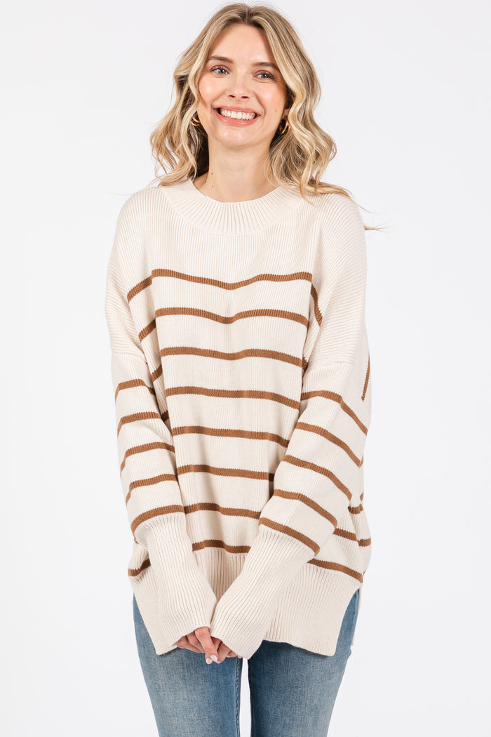 woman wearing a cream and brown striped oversized sweater with long sleeves and relaxed fit