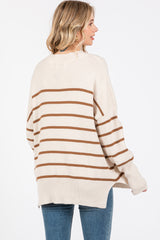 woman wearing a cream and brown striped oversized sweater with a rounded hem and long sleeves