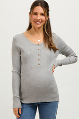 woman wearing a gray ribbed maternity sweater with button details and a visible baby bump