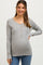 woman wearing a gray ribbed maternity sweater with button details and a visible baby bump
