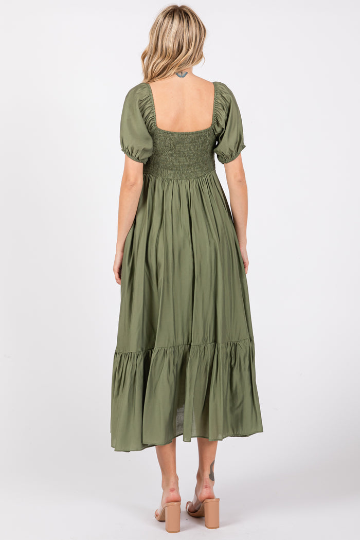 woman wearing a green smocked back maxi dress with puff sleeves and a tiered skirt, seen from the back