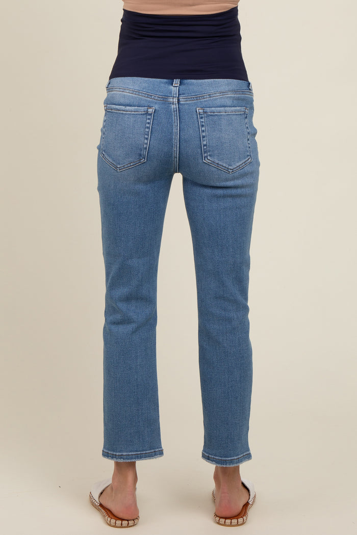 woman wearing a pair of blue maternity jeans, showing the back view with a fitted waist and straight leg cut