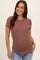 woman wearing a rust short sleeve ribbed maternity top and showing her baby bump