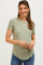 woman wearing a light green short sleeve maternity top and showing her baby bump