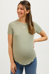woman wearing a sage green short sleeve maternity top with a fitted style and visible baby bump