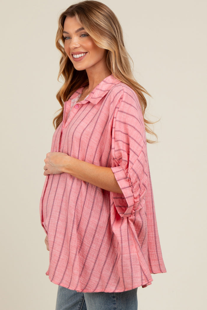 woman wearing a pink striped maternity top and holding her baby bump