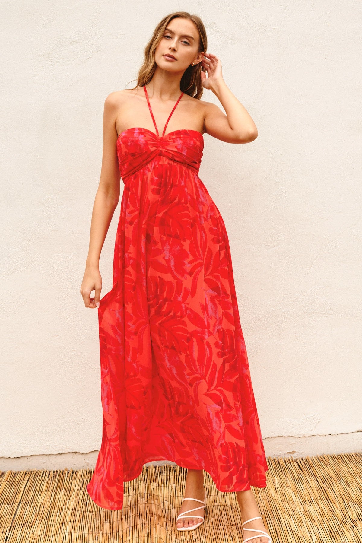 woman wearing a red floral maxi dress with a halter neck and adjustable straps