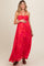 woman wearing a bright floral print maternity maxi dress and holding her baby bump
