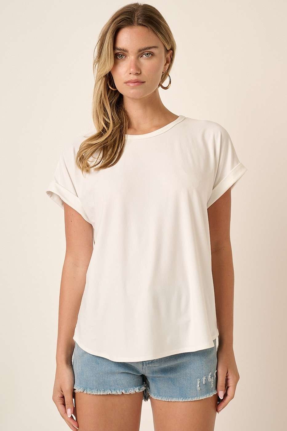 woman wearing a white short sleeve top paired with light blue denim shorts