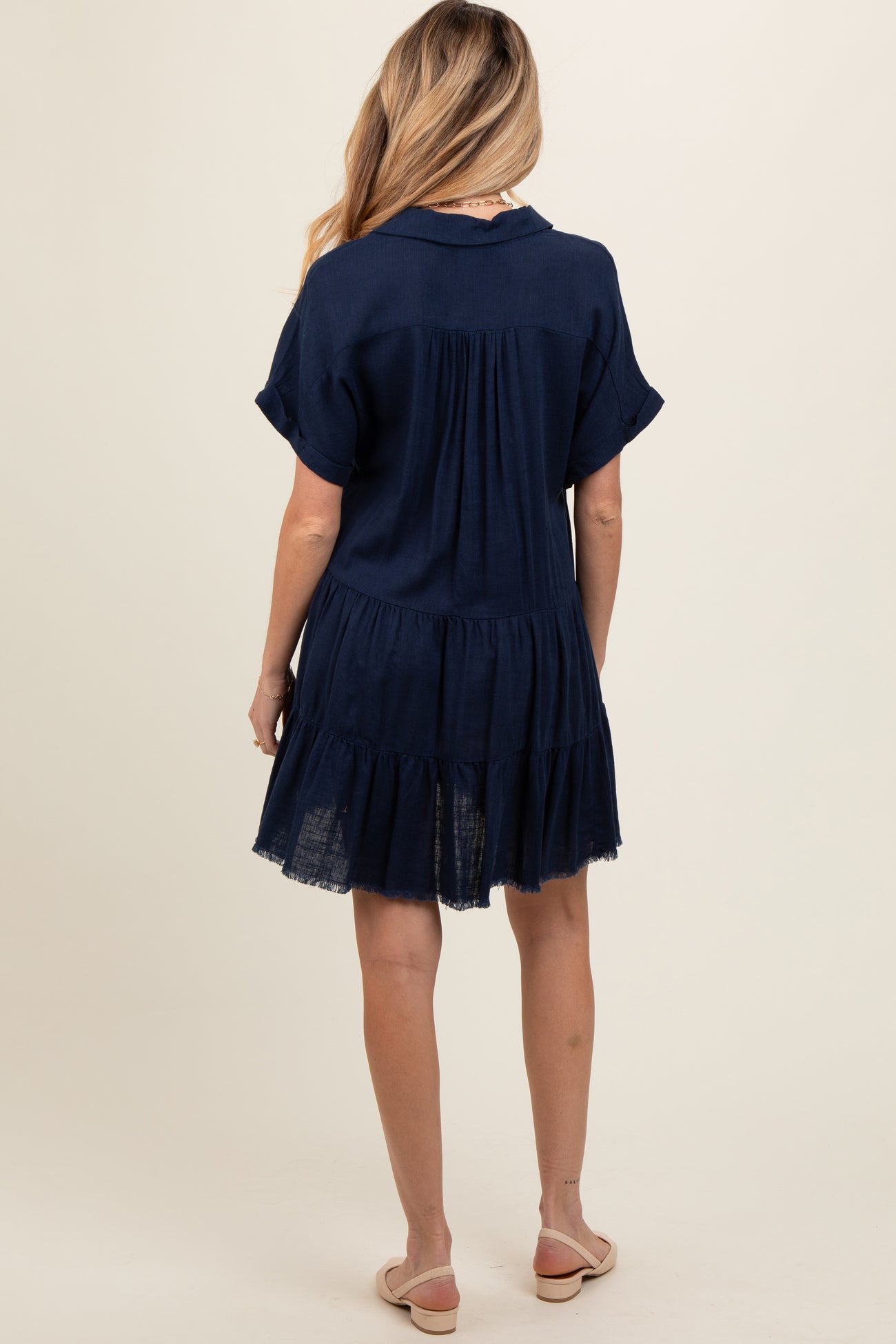 woman wearing a navy blue short sleeve maternity dress with a tiered design and relaxed fit