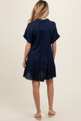 woman wearing a navy blue short sleeve maternity dress with a tiered design and relaxed fit