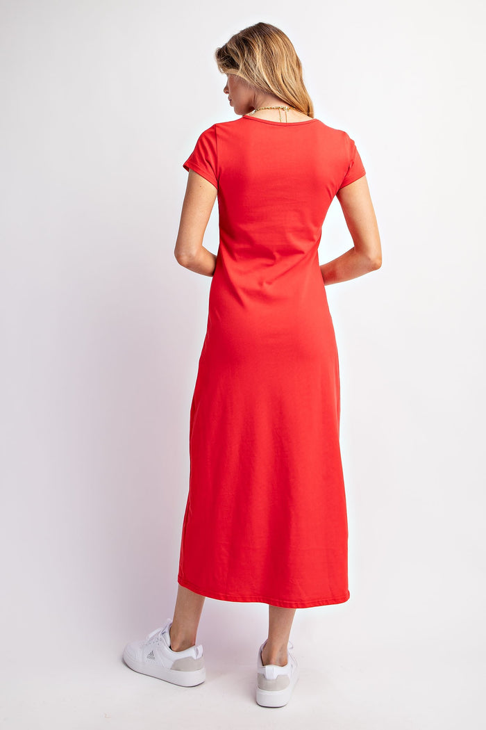 woman wearing a bright red short sleeve maxi dress and white sneakers, seen from the back