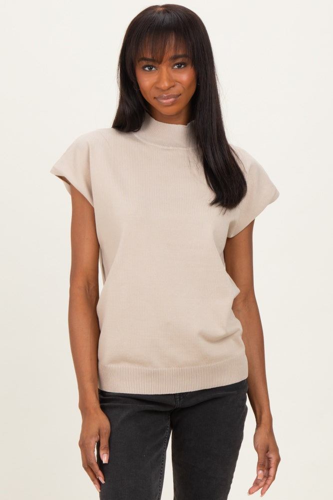 woman wearing a beige short sleeve ribbed mock neck top paired with black jeans