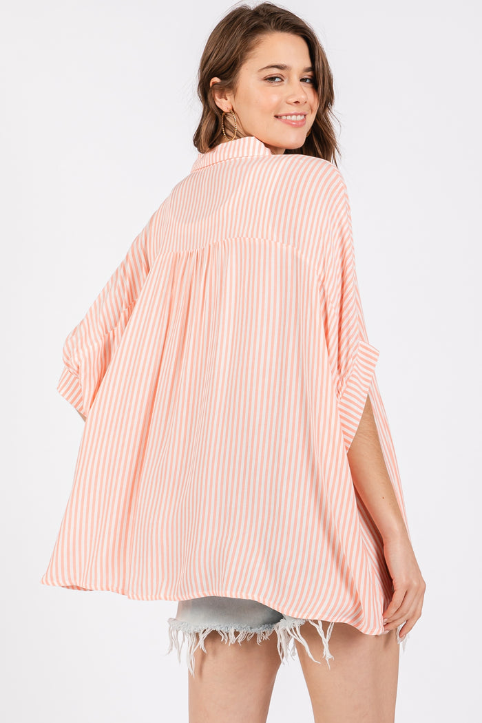 woman wearing a striped peach and white oversized kimono top with short sleeves and a relaxed fit