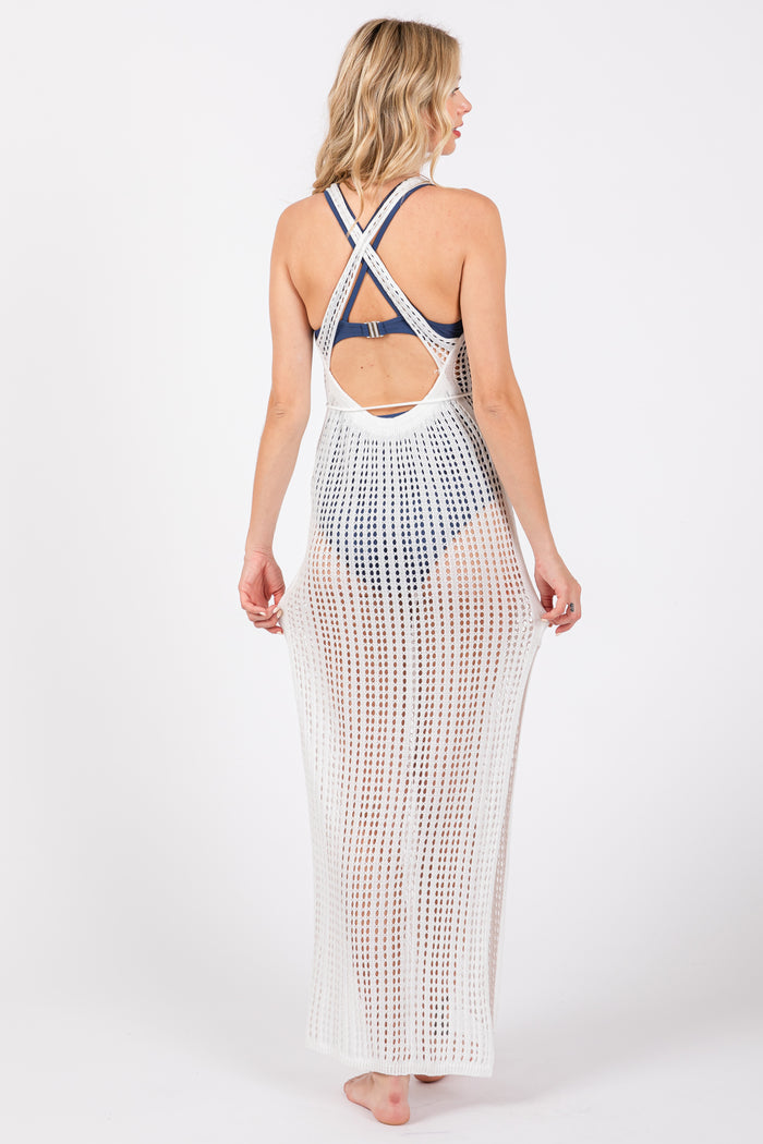 woman wearing a white crochet cover-up with a crisscross back over a swimsuit