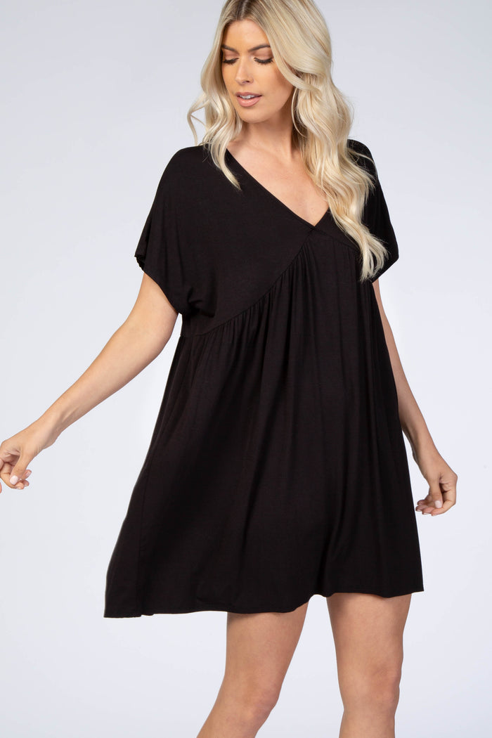 blonde woman wearing a short sleeve black v-neck maternity babydoll dress