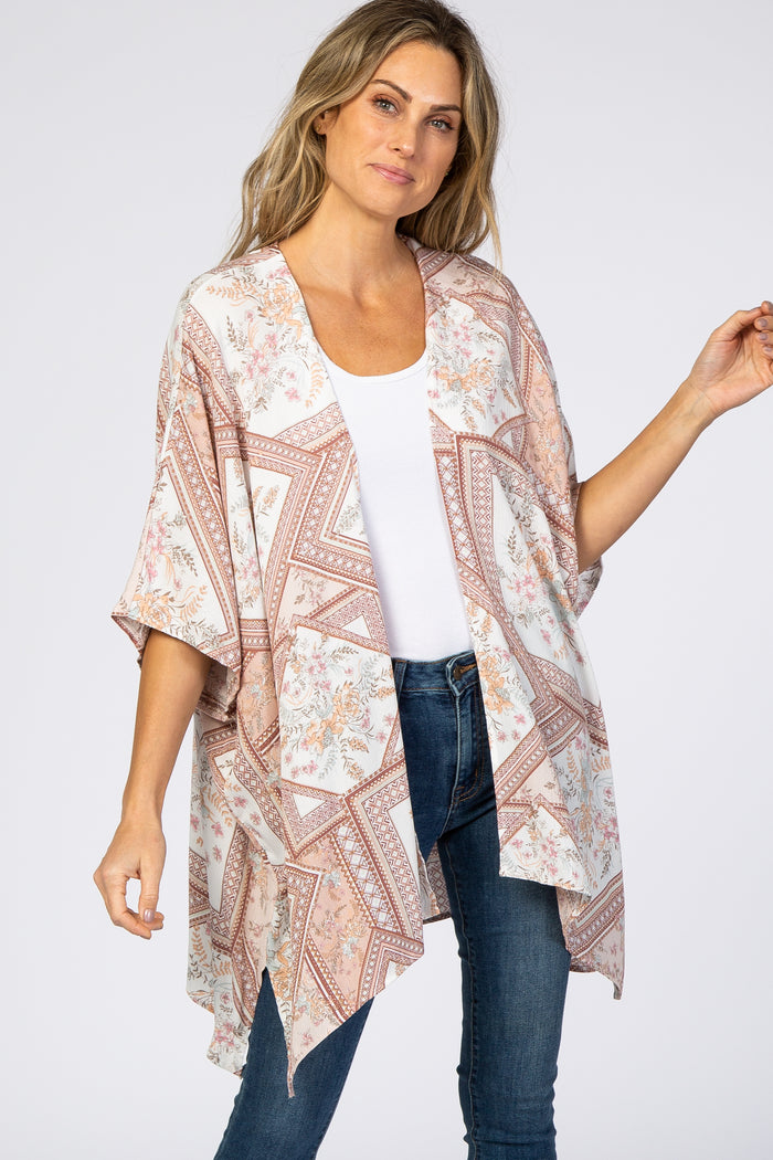 woman wearing a floral and geometric print kimono over a white tank top and blue jeans