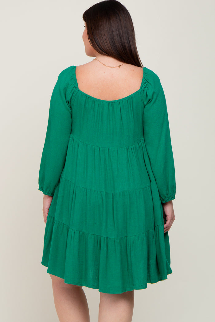 woman wearing a green tiered long sleeve dress, showing the back view and a relaxed fit style