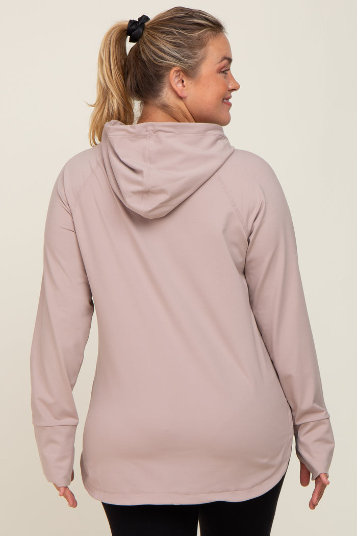 Back view of a woman wearing a mauve long sleeve hooded athletic top with thumbholes