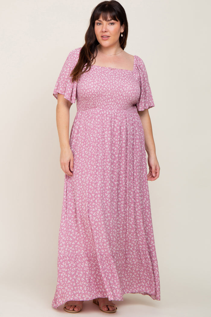 Woman wearing a pink floral smocked maxi dress with flutter sleeves and a square neckline