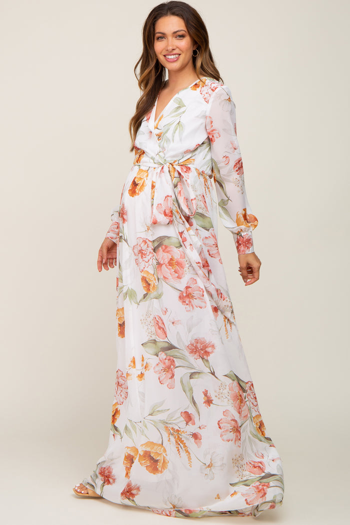 Pregnant woman wearing a white long sleeve floral maternity maxi dress with a waist tie